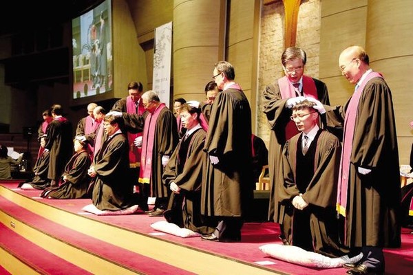 웨이크 목사안수 위원들이 2017년 경기도 구리 두레교회에서 열린 제7회 목사안수식에서 신임 목회자들의 머리에 손을 얹고 기도하고 있다.